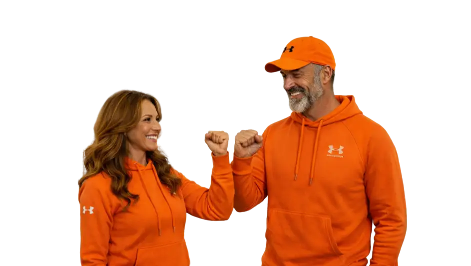 Frau und Mann in orangefarbenen Hoodies und Kappe führen freundliche Faust an Faust-Geste aus.